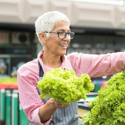 Powerful Nutritional Support — Older woman choosing romaine lettuce