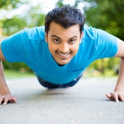 Encourages Regularity – Young man in plank position on cement
