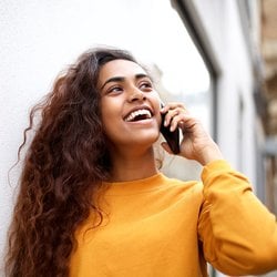 Supports Hair Growth – Woman with full, wavy hair on mobile phone