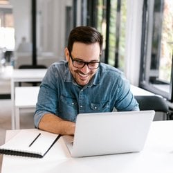 Encourages Brain Health – Man sitting at desk and working on his laptop