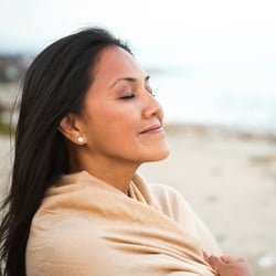 someone meditating by the ocean