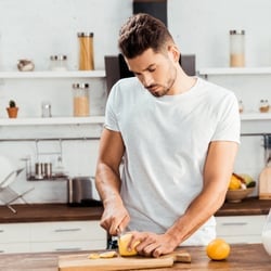 Promotes Detoxification – Man cutting up lemons on a cutting board in the kitchen