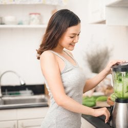 Strengthens the Gut – Young woman blending vegetables in the kitchen