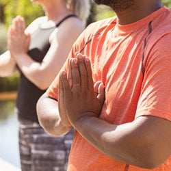 Encourages Healthy Nails – Man and woman practicing yoga with hands in prayer position