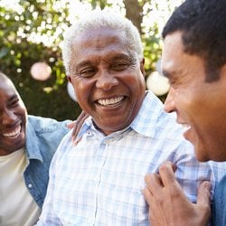 Gets Rid of Digestive Ailments – Trio of men chatting and laughing at an outdoor party