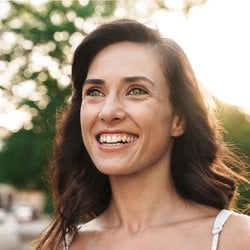 Promotes Regularity - Woman smiling and enjoying the outdoor sun