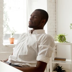 Prepare Your Mind – Man resting in office leaning back in chair with his eyes closed.