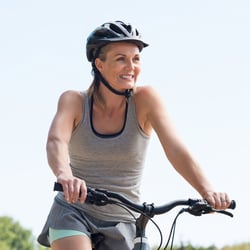 Middle-aged woman wearing a helmet on a bicycle